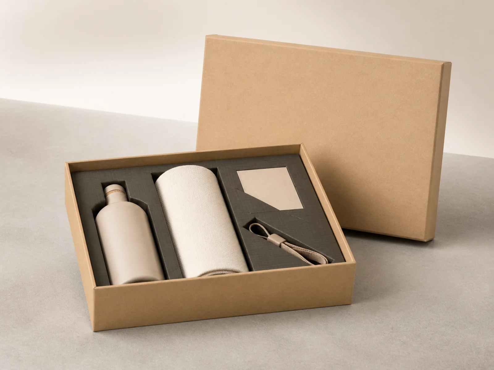 Geöffnete Welcome Kit Box aus Naturkarton mit Flasche und Handtuch